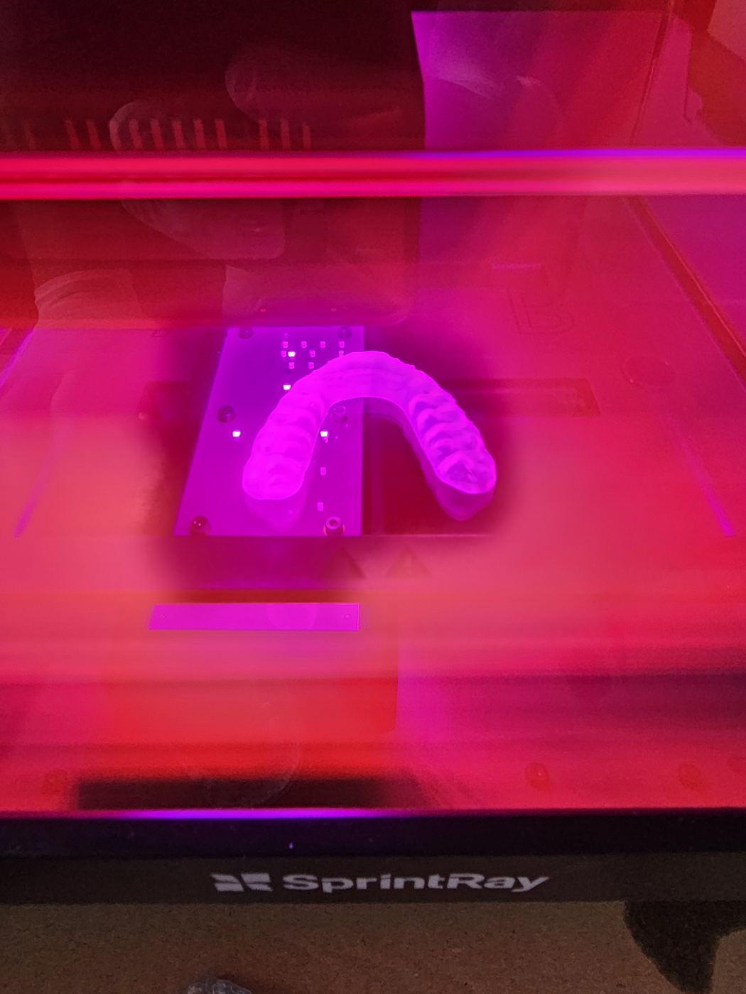 Imprimantă 3D în lucru, cu lumină roz